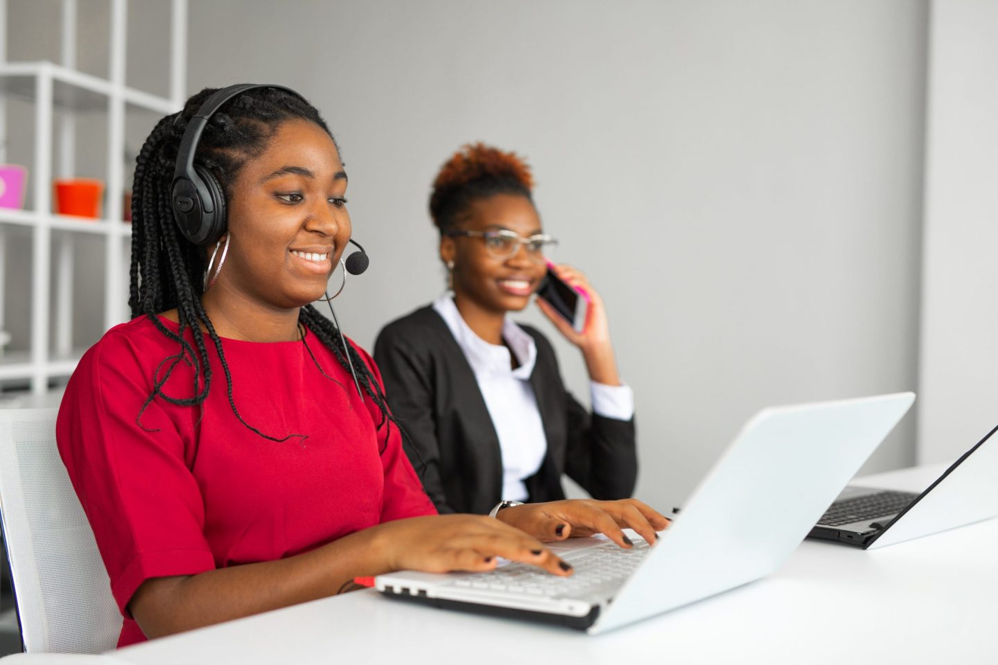 SNS | two beautiful african young women office table with laptop min scaled